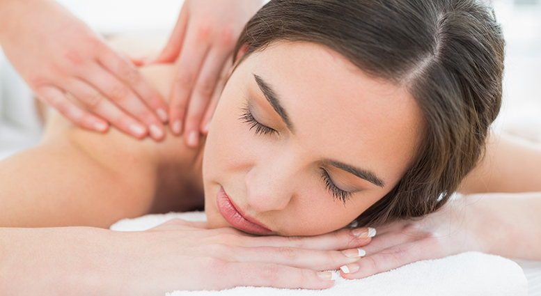 Close up of a beautiful woman enjoying shoulder massage at beaut